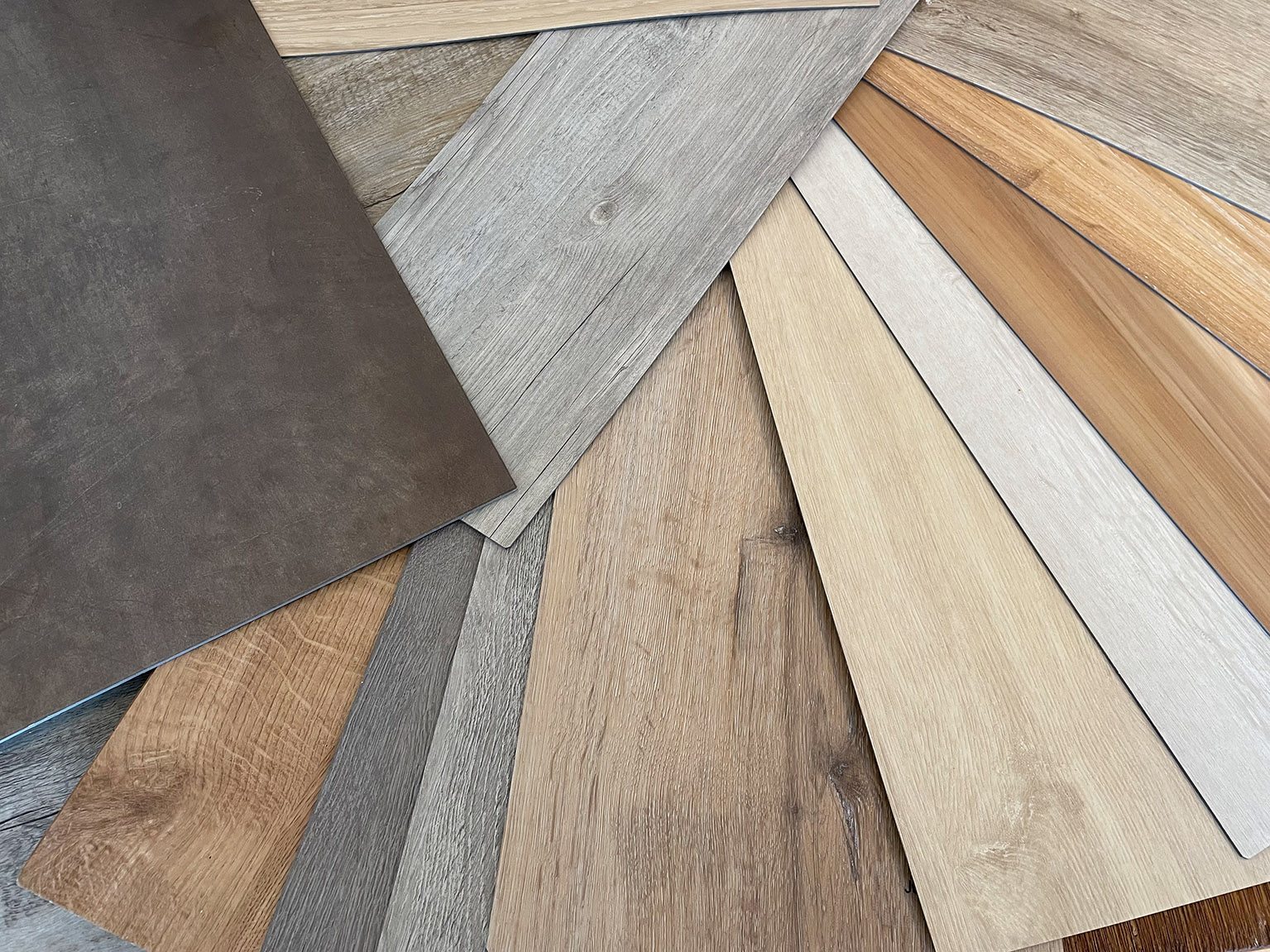 Muster verschiedener Bodenbeläge in Holz- und Steinoptik