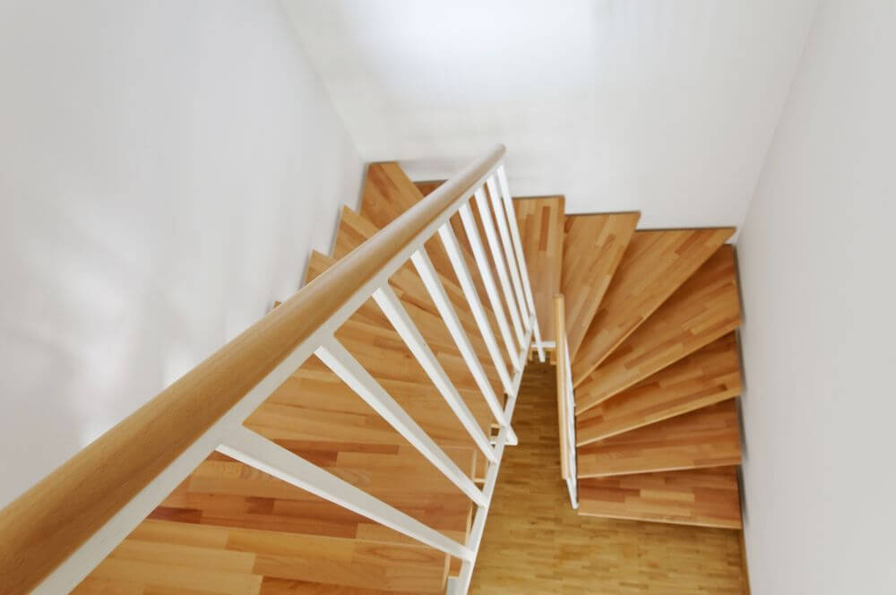 Holztreppe mit Handlauf und weißen Geländerstäben