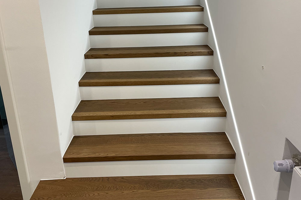 Treppe mit Holzstufen und weißen Setzstufen